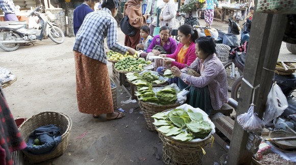 Burmese women in traditional clothes are sellign vegetables and fruit at the Nyang U market, Bagan, Myanmar. Located in the northeastern part of Bagan, Nyaung U market is Nyaung village's local market, where it is possible find goods in different section.