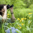 woman in beautiful park watching wildlife with binoculars