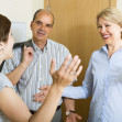 Happy senior family couple visiting adult daughter at home