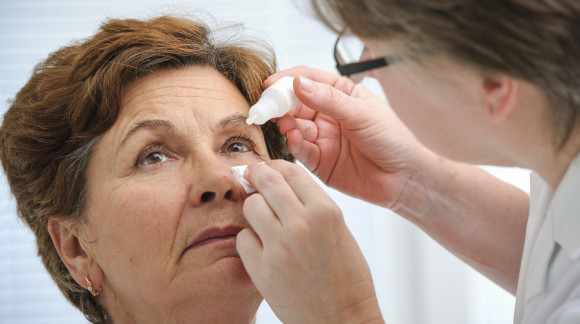 Doctor helps the patient and gives the eye drops