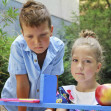 Stylish boy and girl playng school outside. Education and kids fashion concept